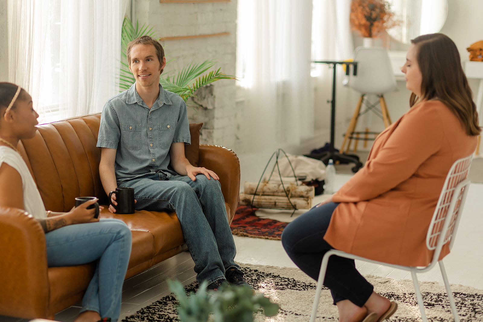 Two women and one man engage in DBT parenting and family therapy at Cincinnati Center for DBT while sitting on a couch in a brightly lit room