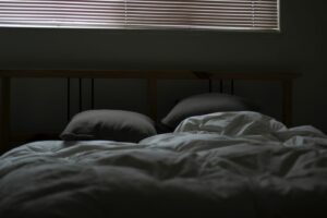 an unmade bed in a dark room