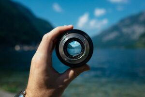 camera lens focusing on mountains and lake