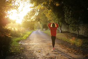 Girl in a red sweatshirt taking a walk through the twilight lit woods