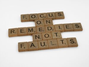 Wooden "scrabble" plates spelling out: focus on remedies not faults.