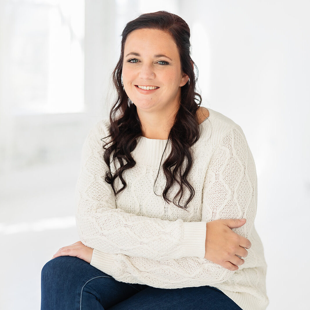 Nikki Heinze Cincinnati Center for DBT Practice Coordinator sits with arms crossed smiling at camera