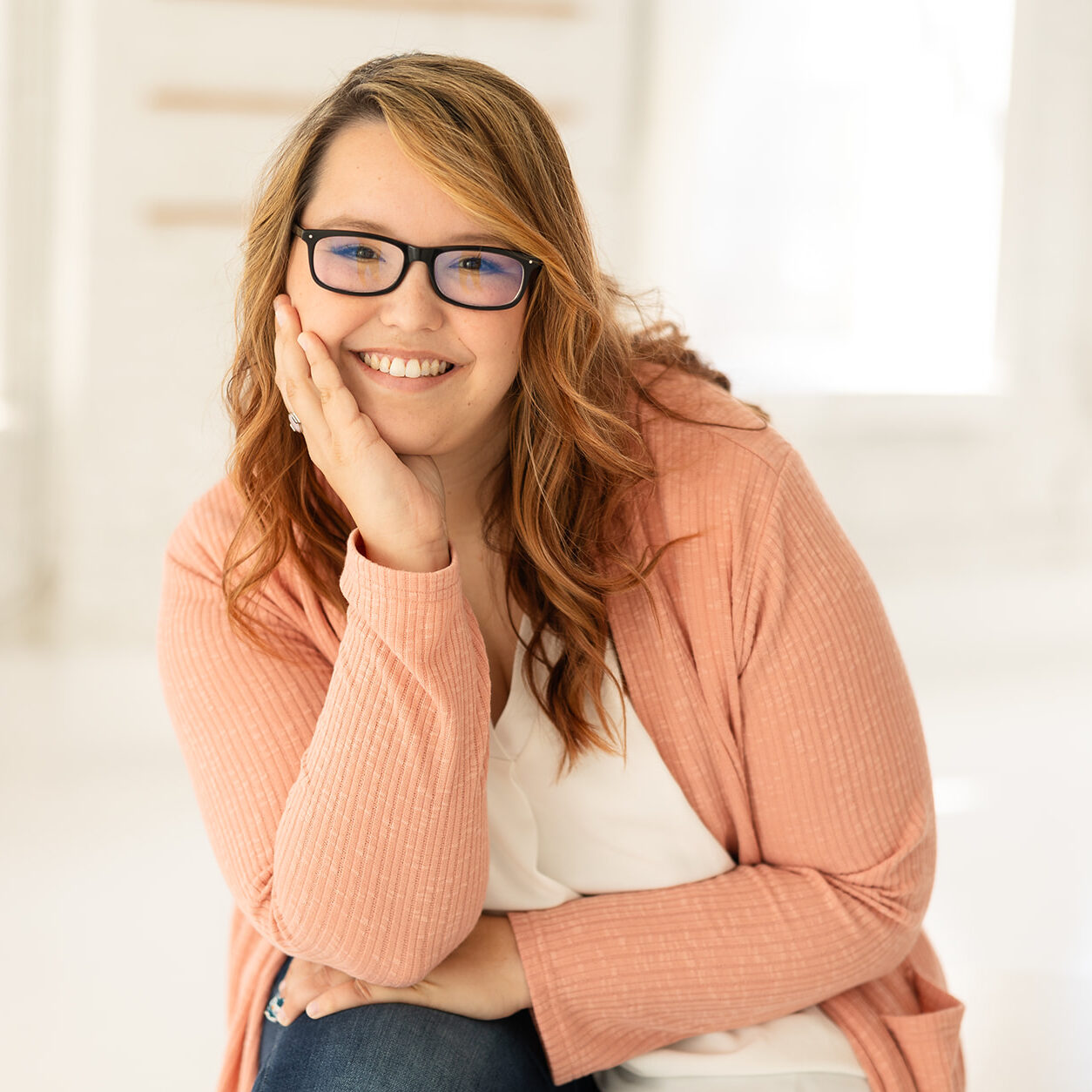 Cincinnati Center for DBT Therapist Madison Beedon smiling at camera with her head in her hand